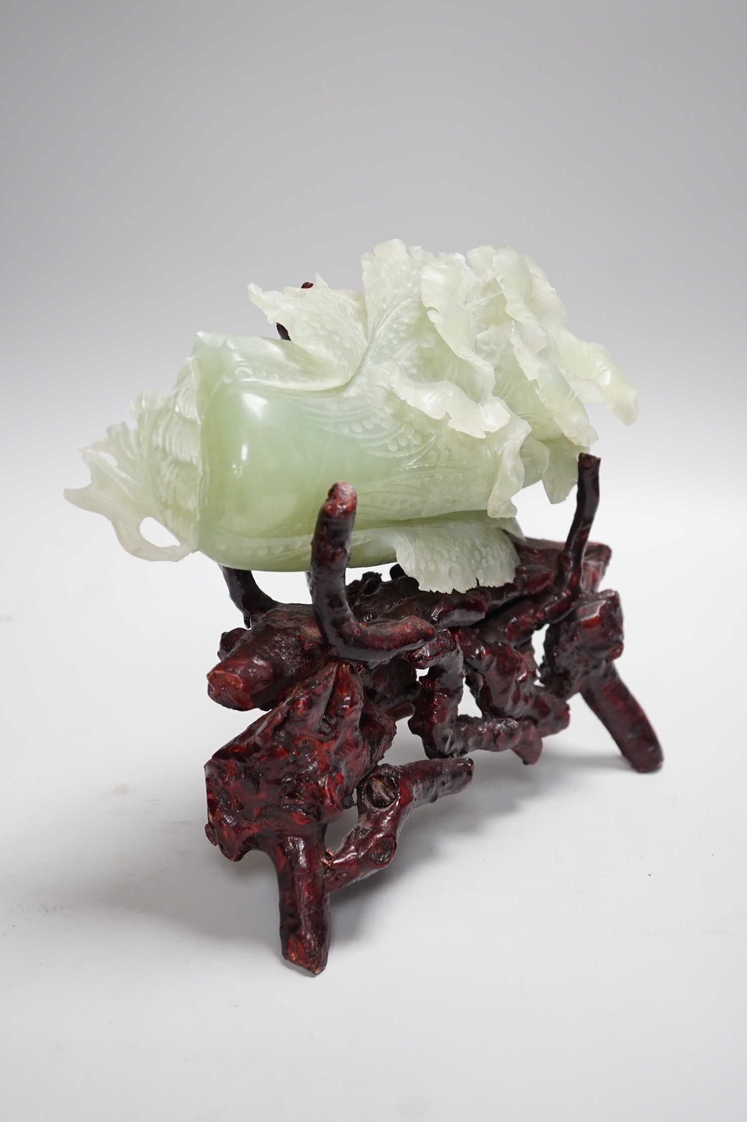 A Chinese bowenite jade carving of a cabbage and a rootwood stand, overall height 24cm